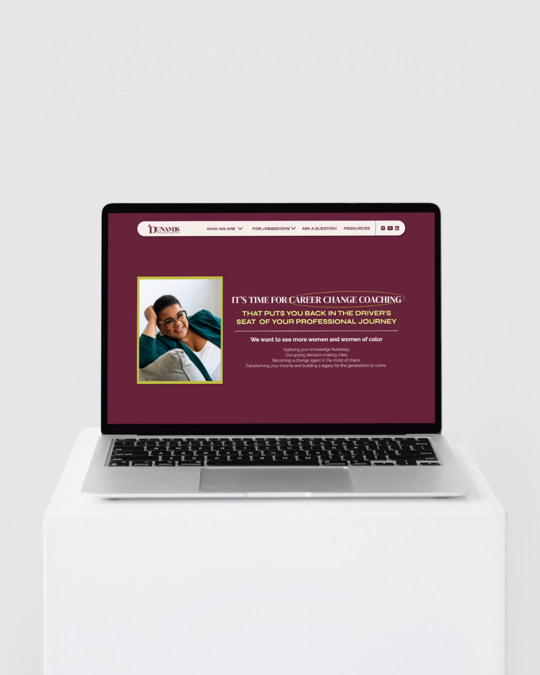 a laptop on a white seat cushion the laptop displays the website for Dunamis Coaching and Consulting 