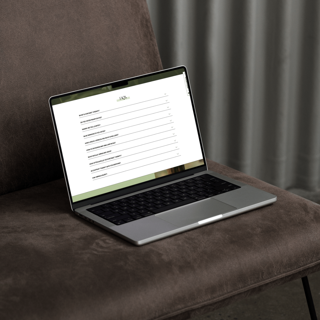 a laptop displaying the website for ash and sage sauna spa set against a black seat 
